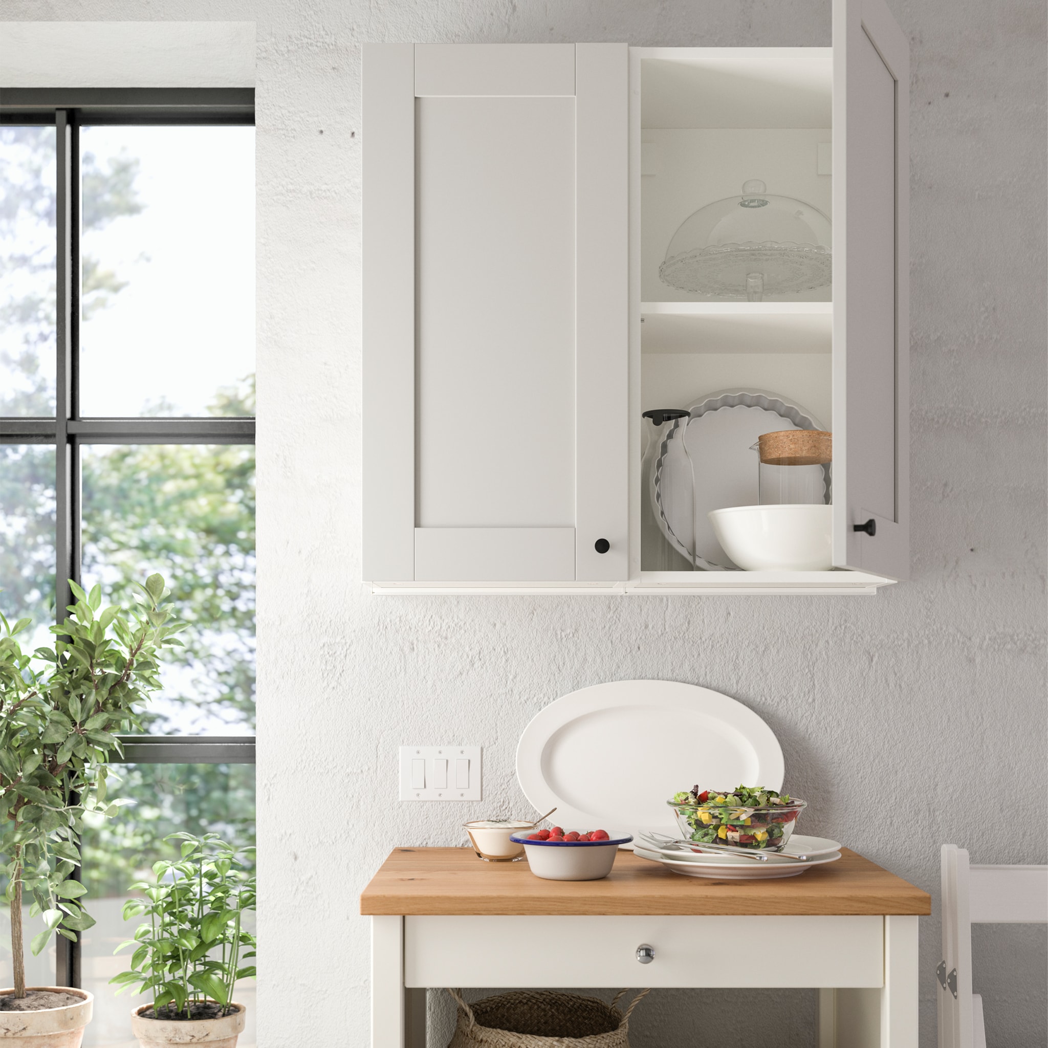  A KNOXHULT grey wall cabinet with a door is mounted on a kitchen wall, and one door is open to show storage inside.