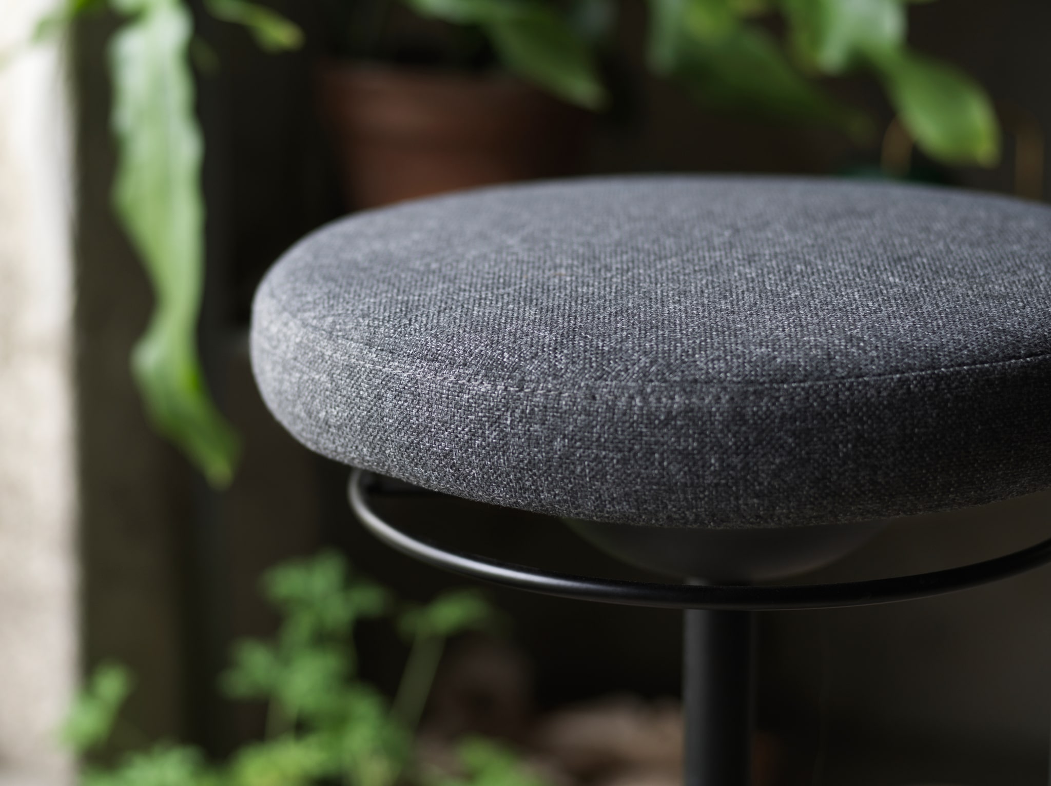 A close-up of LIDKULLEN active sit/stand support with a focus on its rounded padded seat in dark grey.