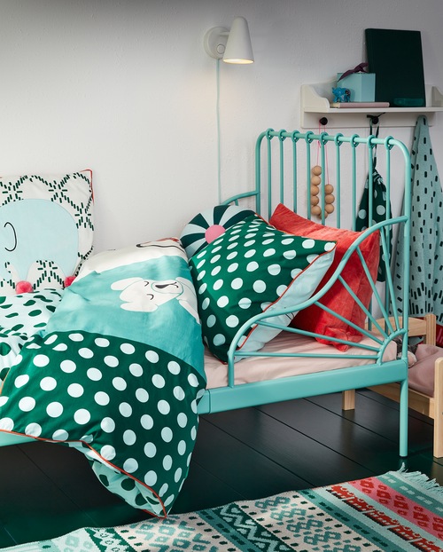 An extendable bed frame in turquoise and KÄPPHÄST bed linen in a patchwork/toys pattern in turquoise, blue and white colours.