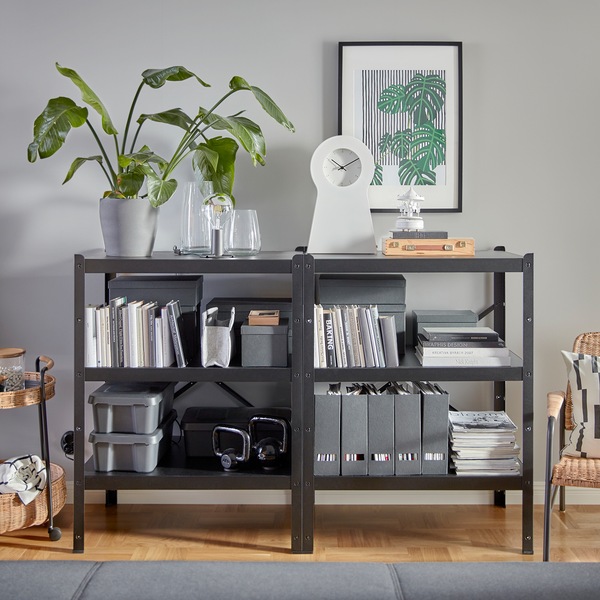 Two black and sturdy BROR shelving units that hold lots of decorative items, books, magazine files, kettlebells and more.