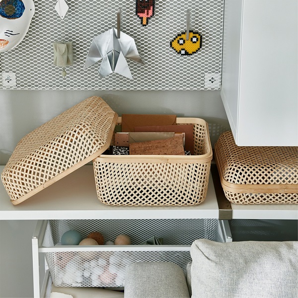 SMARRA box in net-shaped bamboo is standing on a shelf. The lid is off and you can see some notebooks that are stored inside.