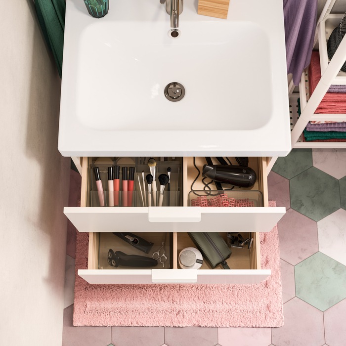 A white wash-stand with two open drawers. Inside are smoked see-through boxes that help organise makeup and more.