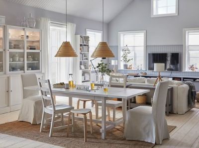  A spacious and bright dining room with a connected living room. The dining table is extended, and stools provide more seats.