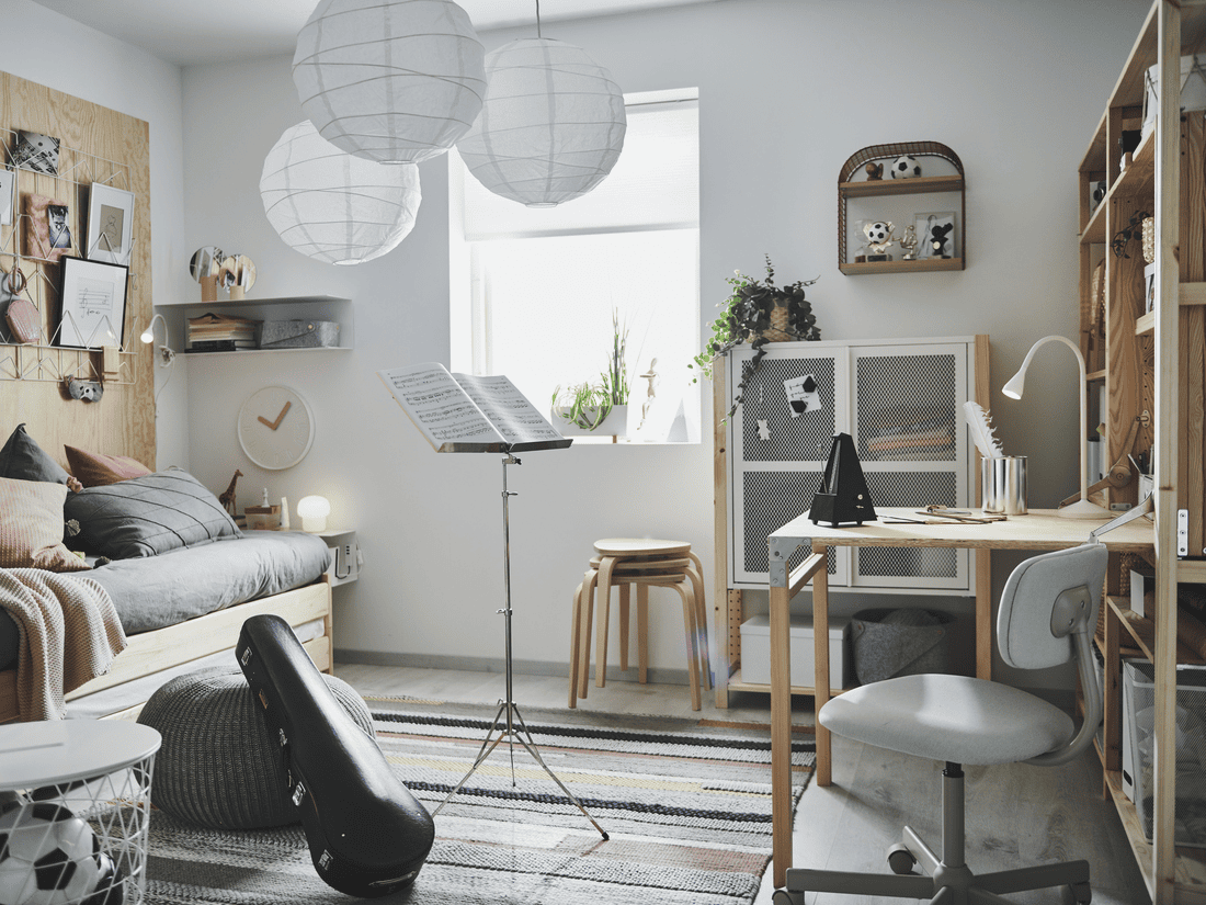 UTÅKER stackable bed near a window with a table for working