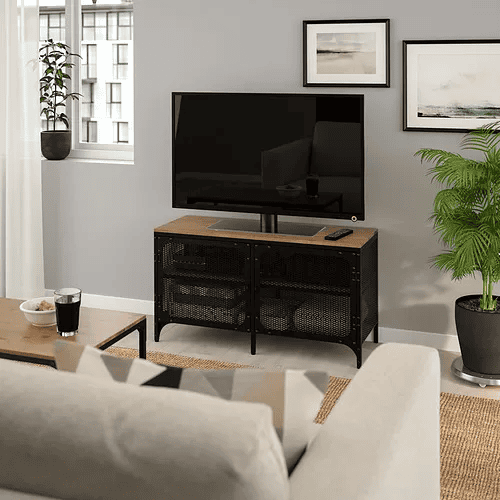 Kabinet TV FJÄLLBO dengan rangka logam hitam dan pintu jaring.