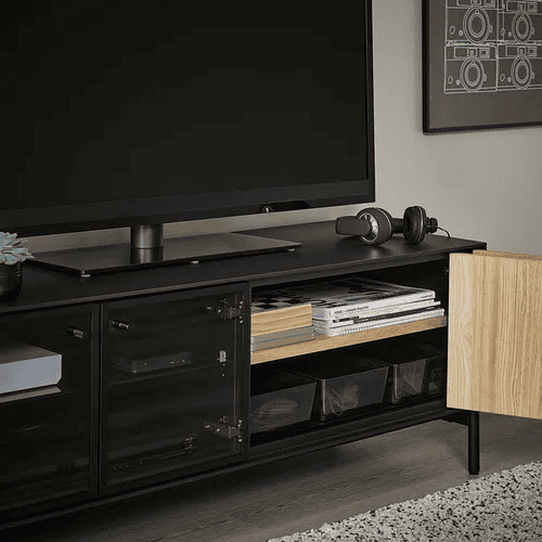 Kabinet TV dengan pintu tertutup untuk menyimpan remote dan kabel.